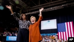 Đệ nhất Phu nhân Michelle Obama (trái) và ứng cử viên tổng thống đảng Dân chủ Hillary Clinton trong một cuộc mít tinh tại Đại học Wake Forest ở Winston-Salem, North Carolina, 27/10/2016.