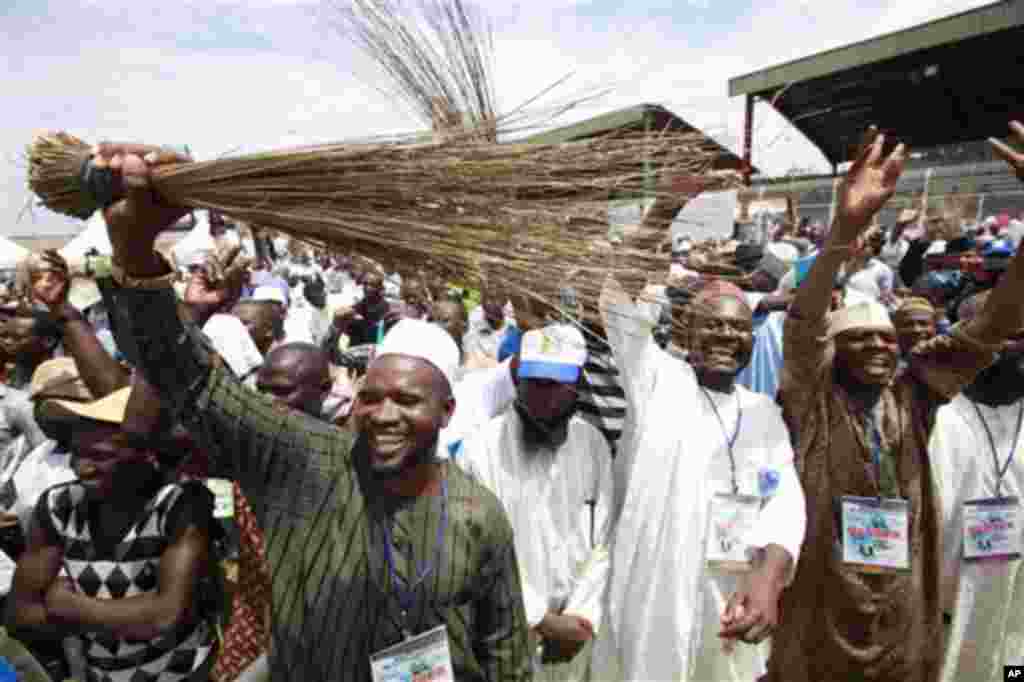Members of All Progressives Congress party waves brooms the symbol of the party as former military ruler and Presidential aspirant Muhammadu Buhari, delivered a speech during the party convention in Lagos, Nigeria,Thursday, April. 18, 2013.