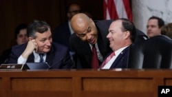 (L-R) Sen. Ted Cruz, R-Texas, Sen. Cory Booker, D-N.J., and Sen. Mike Lee, R-Utah, confer on the last day of the Senate Judiciary Committee's confirmation hearing for President Donald Trump's Supreme Court nominee, Brett Kavanaugh, on Capitol Hill in Washington, Sept. 7, 2018. 