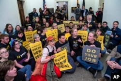 Environmental activists occupy the office of Rep. Steny Hoyer, D-Md., the incoming majority leader, as they try to pressure Democratic support for a sweeping agenda to fight climate change, on Capitol Hill in Washington, Dec. 10, 2018.