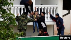 Serbian army soldiers evacuate a boy from a flooded house in the town of Obrenovac, southwest of Belgrade, Serbia, May 17, 2014. 
