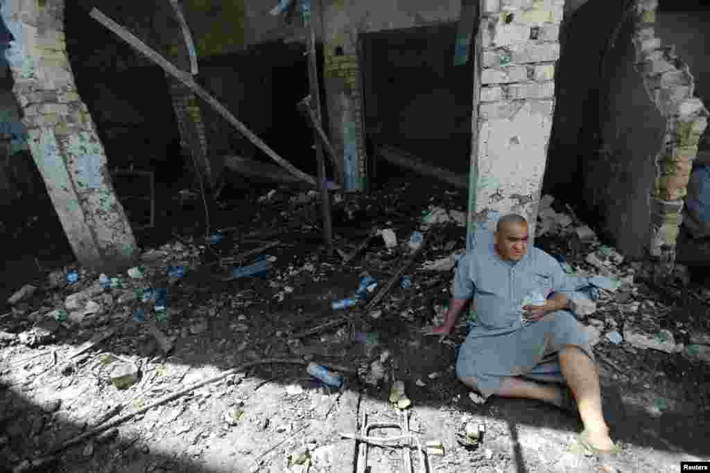 A man sits at the site of a suicide attack at the entrance of the Shi'ite Mausoleum of Sayid Mohammed bin Ali al-Hadi in Balad, north of Baghdad, Iraq. Islamic State terrorists killed at least 35 people and wounded scores of others late Thursday in the attack.