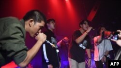 An audience member, second from right, raps with members of Rap Against Dictatorship on stage in Bangkok, Oct. 27, 2018. The group has touched a nerve with an impassioned and now-viral music video lobbing fiery rhymes at the ruling junta.