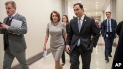 FILE - House Majority Leader Nancy Pelosi of Calif. walks with Rep. Joaquin Castro, D-Texas at the Capitol in Washington.