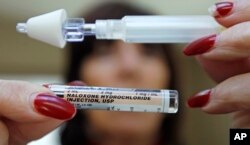 Seorang perempuan memegang ampul Nalokson Hidroklorida yang digunakan untuk penawar overdosis opioid atau obat penenang, 27 Februari 2012.