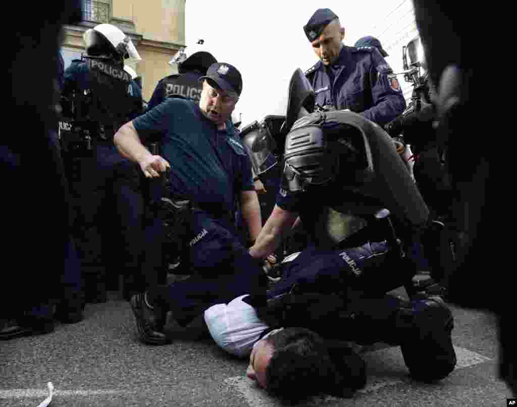 Police detain a supporter of the far-right National-Radical Camp, as they take part in a march to show their opposition to left-wing politics and the labor movement in Warsaw, Poland, May 1, 2018.