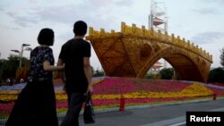 '일대일로' 국제협력 정상 포럼 준비가 한창인 10일 중국 베이징 시내에 설치된 '실크로드 황금다리' 조형물 앞으로 시민들이 지나고 있다.
