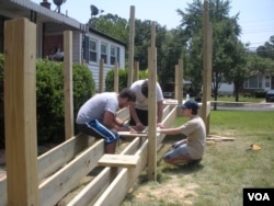 Yachad's teen volunteers build a wheelchair ramp at the New Carrollton, Maryland, home of Herson Portillo, 21, who has had cerebral palsy since birth. (Julie Taboh/VOA)