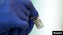 FILE - A medical worker holds a vial of the Pfizer-BioNTech coronavirus disease (COVID-19) vaccine at Tokyo Medical Center, as Japan launches its inoculation campaign, in Tokyo, Feb. 17, 2021.