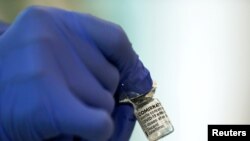 FILE - A medical worker holds a vial of the Pfizer-BioNTech coronavirus disease (COVID-19) vaccine at Tokyo Medical Center, as Japan launches its inoculation campaign, in Tokyo, Feb. 17, 2021.
