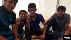Mohammad, 16, center, and his cousin and brother escaped IS militants three days ago after their house collapsed, killing Mohammad's baby cousin and uncle. June 23, 2017, in Hammam Alil, Iraq. (H. Murdock/VOA) 