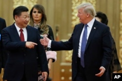 FILE - U.S. President Donald Trump China's President Xi Jinping arrive for the state dinner with the first ladies at the Great Hall of the People in Beijing, China, Nov. 9, 2017.