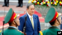 日本首相菅义伟在越南河内总统府检阅仪仗队。（2020年10月19日）