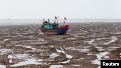 A fishing boat is seen during the low tide at the beach in Thanh Hoa province, Vietnam June 4, 2018.