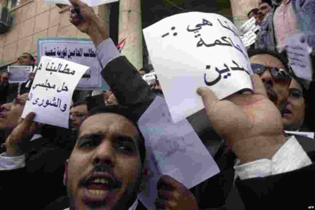 Egyptian lawyers in black robes shout anti-Mubarak slogans in front of their syndicate in Cairo, Egypt, Thursday, Feb.10, 2011. Labor unrest across the country gave powerful momentum to Egypt's wave of anti-government protests. With its efforts to manage 