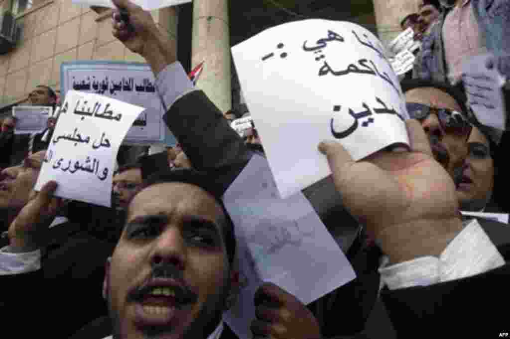 Egyptian lawyers in black robes shout anti-Mubarak slogans in front of their syndicate in Cairo, Egypt, Thursday, Feb.10, 2011. Labor unrest across the country gave powerful momentum to Egypt's wave of anti-government protests. With its efforts to manage