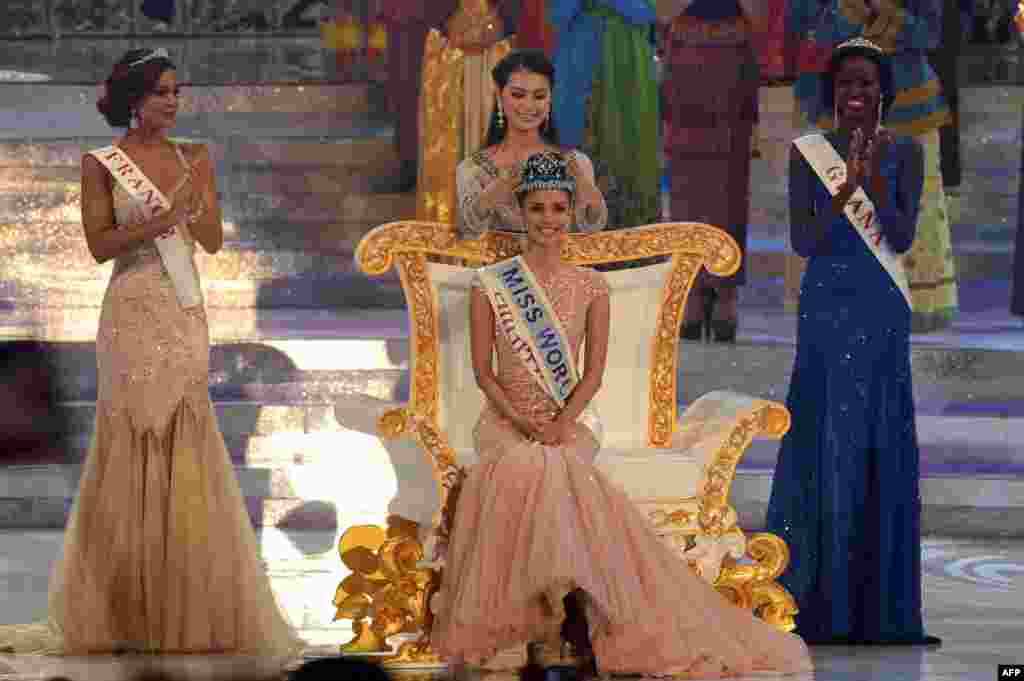 Tân Hoa hậu Thế giới, Megan Young (giữa) của Philippines, được Hoa hậu Thế giới năm ngoái Vu Văn Hà trao vương miện. Bên cạnh là Á hậu 1 Marine Lorphelin (trái) của Pháp và Á hậu 2 Carranzar Naa Okailey (phải) của Ghana trong đêm chung kết Hoa hậu Thế giới 2013 ở Nusa Dua, khu du lịch trên đảo Bali của Indonesia. 