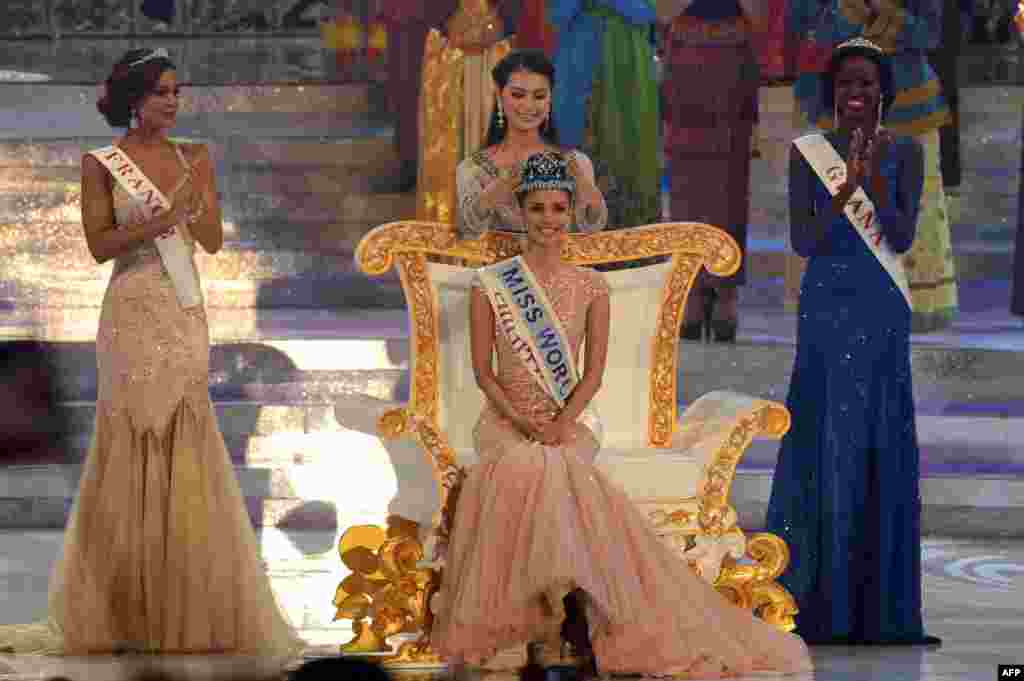 New Miss World, Megan Young (C) from the Philippines is crowned by outgoing Miss World Yu Wenxia after winning the crown as first runner up, Marine Lorphelin (L) of France and second runner up Carranzar Naa Okailey (R) from Ghana look on during the Miss World 2013 finals in Nusa Dua, in Indonesia's resort island of Bali.