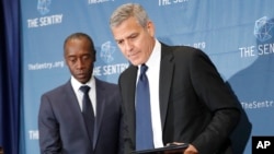 Actors George Clooney, right, and Don Cheadle, left, arrive for a press conference to discuss an investigation about corruption in South Sudan at the National Press Club in Washington, D.C. Sept. 12, 2016.