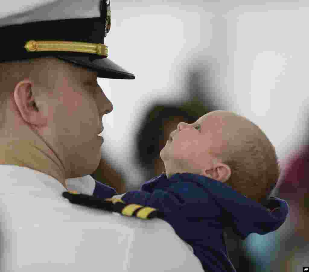 Six-week-old Ewan Bingham, takes a look at his dad, Lt. Chris Bingham, of Cranford, New Jersey, after Chris disembarked from the USS Harry S. Truman in Norfolk, Virginia. The carrier strike group is returning from a nine-month deployment. There were 171 babies born to sailors aboard the ship during the deployment.