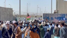 Crowds of people show their documents to U.S. troops outside the airport in Kabul, Afghanistan August 26, 2021. REUTERS/Stringe