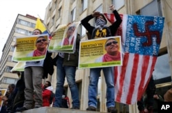 FILE - Supporters of Seuxis Paucias Hernandez, better known by his alias Jesus Santrich, a leader of the former Revolutionary Armed Forces of Colombia (FARC), hold posters asking for his freedom during a demonstration marking May Day to honor workers.