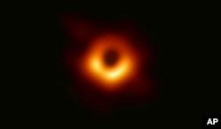 This image released Wednesday, April 10, 2019, by Event Horizon Telescope shows a black hole.