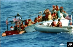 FILE - U.S. Coast Guard crew members are hindered by rough seas in the Florida Straits as they attempt to rescue Cuban refugees, Aug. 27, 1994.
