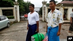 Burmese political prisoners Win Thaw (L) and Win Hla (R) stand outside the entrance of the Insein Prison upon their release. (file) 