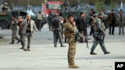 Security forces inspect the site of a deadly blast near a demonstration by hundreds of minority Shiites, in the center of Kabul, Afghanistan, Monday, Nov. 12, 2018. (AP Photo/Massoud Hossaini)