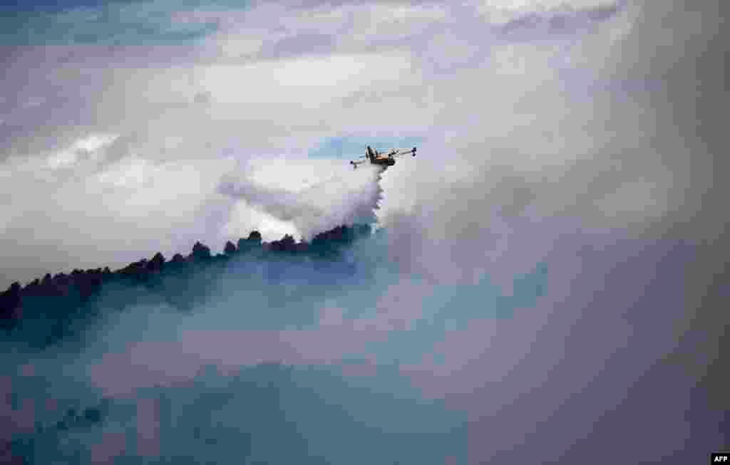 A fire fighting Canadair aircraft drops water over a fire in Mirabeau, southeastern France.