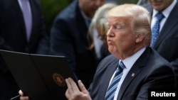 President Donald Trump prepares to sign the Executive Order on Promoting Free Speech and Religious Liberty during a National Day of Prayer event at the Rose Garden of the White House in Washington, May 4, 2017.
