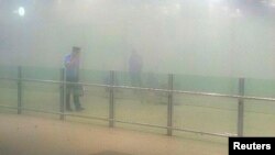 A policeman stands amid smoke at arrival gate B after an explosion at Terminal 3 of Beijing Capital International Airport in Beijing July 20, 2013. 