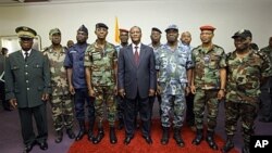 Ivory Coast's President Alassane Ouattara (C) poses with General Philippe Mangou (4L), chief of staff of former pro-Laurent Gbagbo Defense and Security Forces (FDS), and other military officers during a ceremony at the Hotel du Golf in Abidjan on April 12
