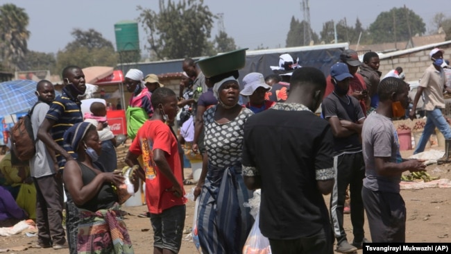 People are seen at a busy market in a poor community outside the capital Harare on November 15, 2021. (AP Photo/Tsvangirayi Mukwazhi)