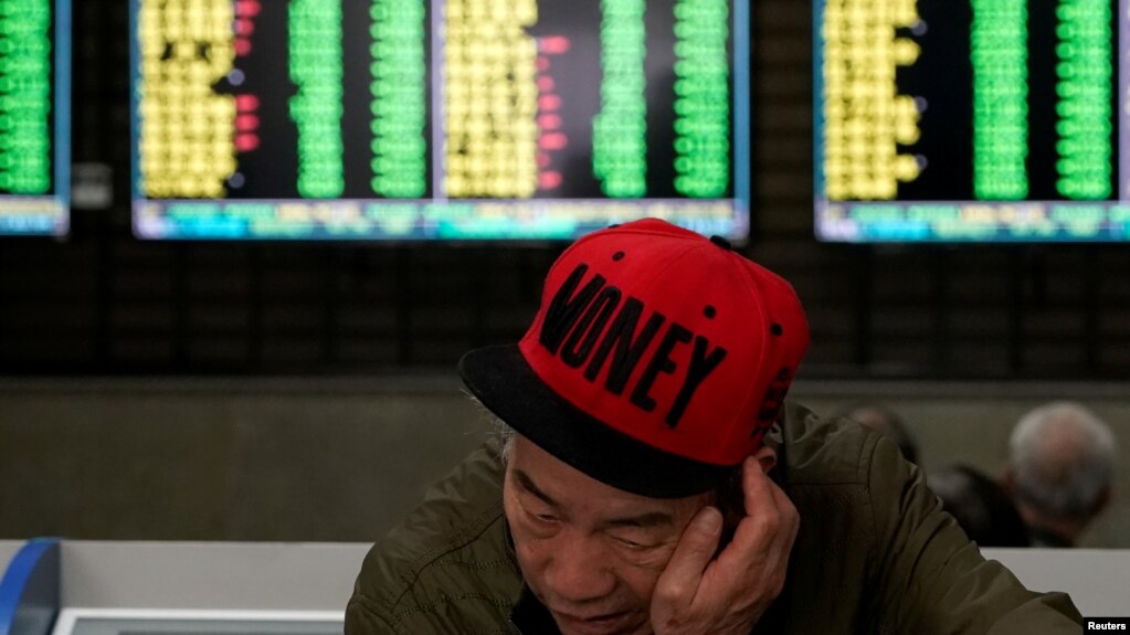 一名男子2019年5月6日在上海一家股市交易所查看股市行情。(photo:VOA)