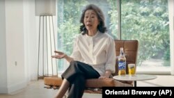 Dalam tangkapan layar video iklan, aktris Korea Selatan Youn Yuh-jung, pemeran dalam film "Minari" menjadi bintang iklan produsen bir, Oriental Brewery. (Foto: Oriental Brewery via AP)