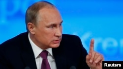 FILE - Russian President Vladimir Putin, shown at a news conference, has signed a revised military doctrine listing NATO and the United States as national security threats.