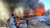 Des pompiers palestiniens éteignent un incendie dans un entrepôt de peinture qui, selon des témoins, a été touché par des frappes israéliennes à Rafah, dans le sud de la bande de Gaza, le 18 mai 2021.