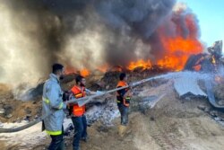 Petugas pemadam kebakaran Palestina memadamkan api di gudang cat yang menurut saksi terkena serangan Israel, di tengah pertempuran Israel-Palestina, di Rafah di Jalur Gaza selatan 18 Mei 2021. (Foto: REUTERS/Bassam Masoud)