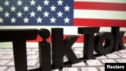 FILE: A 3D printed Tik Tok logo is placed on a keyboard in front of U.S. flag in this illustration taken October 6, 2020. Tik Tok has been accused of spreading U.S. election misinformation. 