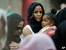 Muhammad Ali's wife, Lonnie, and her daughter Laila attend Muhammad Ali's Jenazah, a traditional Muslim service, at Freedom Hall in Louisville, Ky., June 9, 2016. Laila is holding her daughter, Sydney Jurldine Conway.