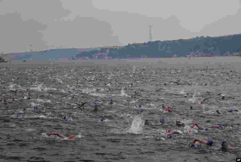Athletes swim from Asia to Europe in the Bosphorus strait during the Bosporus Cross-Continental Swimming Race in Istanbul, Turkey.