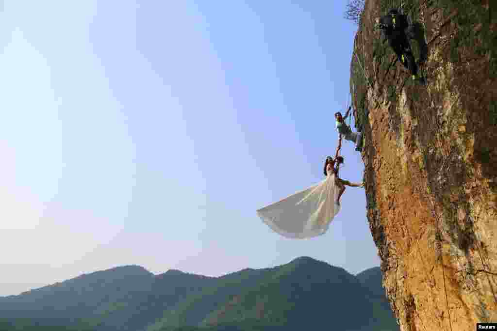 Zheng Feng, seorang pemanjat tebing amatir melakukan foto pernikahan bersama pasangannya di sebuah tebing karang di&nbsp;Jinhua, Zhejiang, China. 