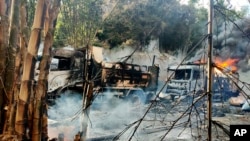 In this photo provided by the Karenni Nationalities Defense Force (KNDF), smoke and flames billow from vehicles in Hpruso township, Kayah state, Myanmar, Dec. 24, 2021. 