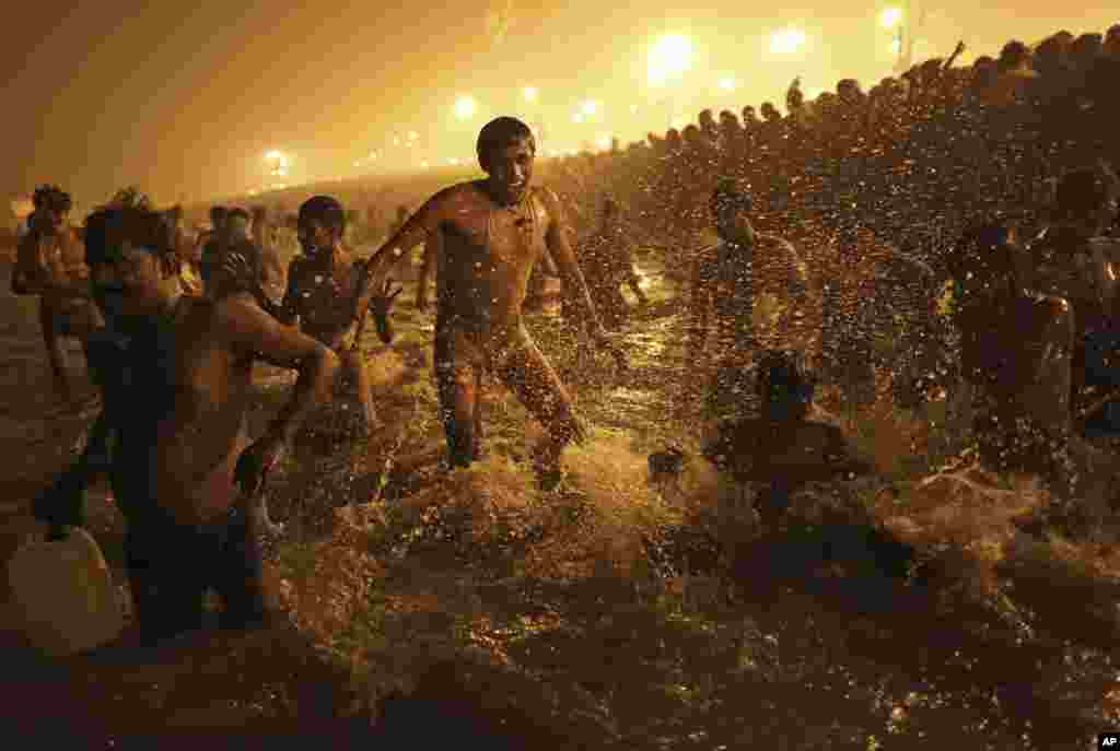 An Indian Hindu man jumps up and down in the water as he takes a dip at Sangam, the confluence of the rivers Ganges, Yamuna and mythical Saraswati, during the Kumbh Mela festival in Allahabad, India, January 14, 2013.