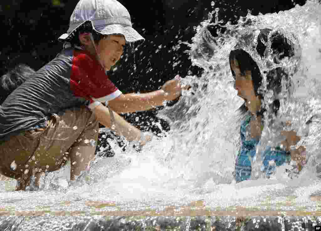 일본 도쿄의 아스카 공원 분수에서 어린이들이 물장난을 치고 있다.
