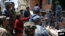 27일 네팔 카트만두의 지진으로 무너진 건물에서 구조요원들이 생존자 수색 작업을 벌이고 있다.