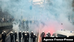 Protesters face riot police as they take part in a demonstration against COVID-19 measures, including the country's health pass, in Brussels, Belgium, Nov. 21, 2021.