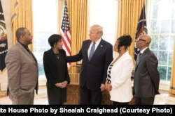 President Donald Trump welcomes State of the Union honored guests, from left, Robert Mickens, Evelyn Rodriguez, Elizabeth Alvarado and Freddy Cuevas to the Oval Office at the White House, Jan. 30, 2018, in Washington, D.C.